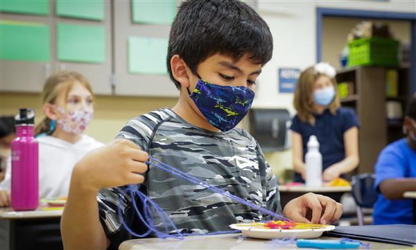 student creates woven craft